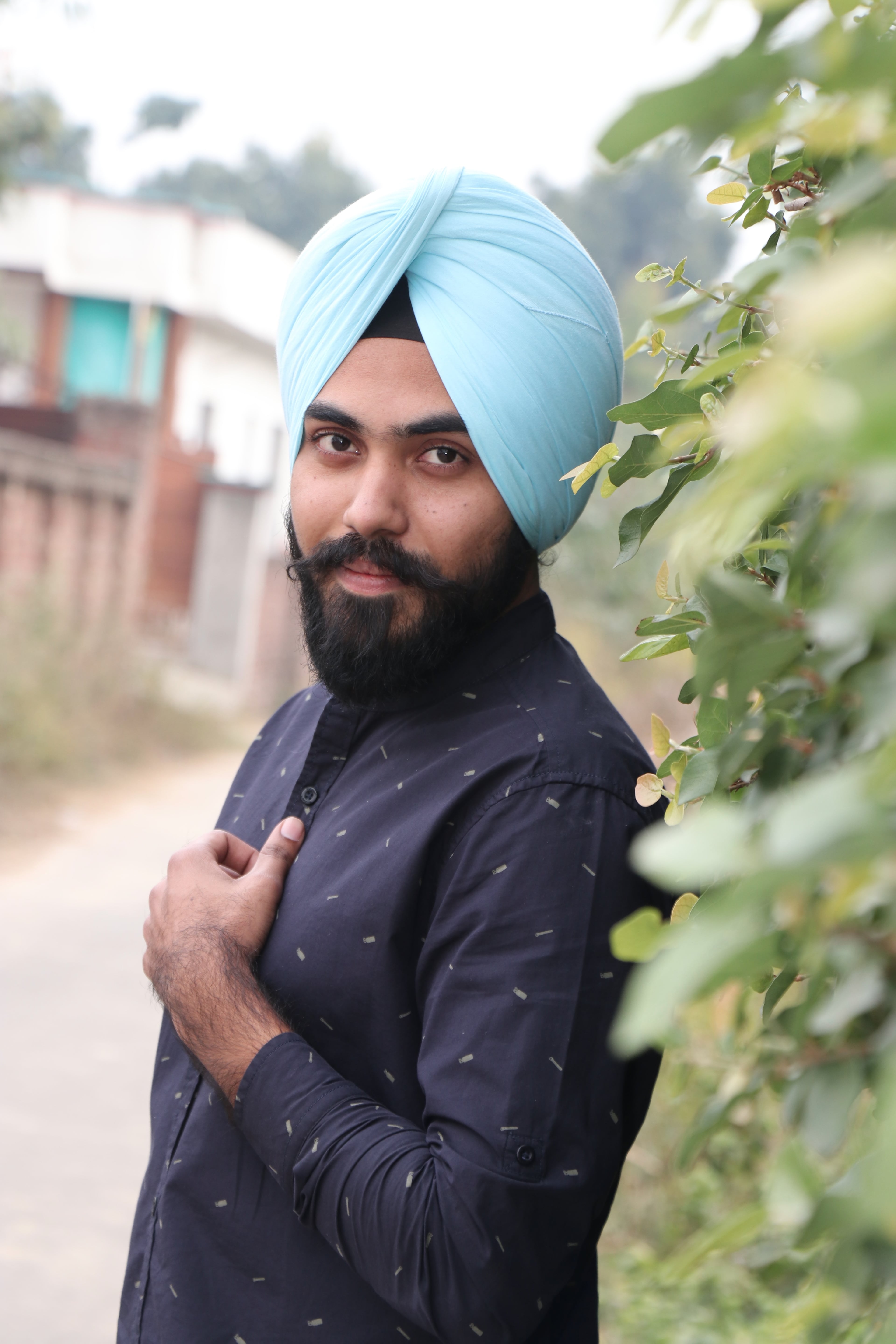 Harman Singh outdoors, wearing a light blue turban and navy kurta